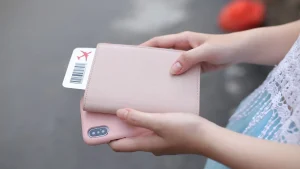 Person haelt eine Passhuelle mit Bordkarte in der Hand vor einer Reise
