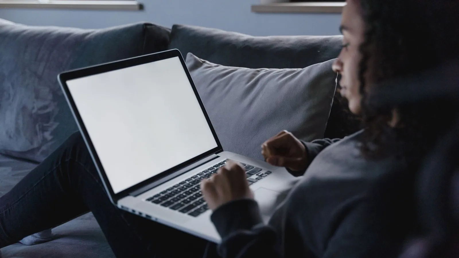 Person wartet vor einem Laptop-Bildschirm waehrend ein Windows 11 Update installiert wird