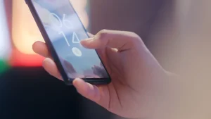 Person entsperrt Smartphone per Fingerabdruck als Beispiel fuer Zwei-Faktor-Authentifizierung